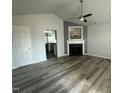 Bright living room featuring a fireplace, ceiling fan, and views into kitchen at 104 Ginger Cir, Selma, NC 27576
