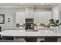 Modern kitchen featuring stainless appliances, white cabinets, and an oversized island at 105 Sunstone Dr, Cary, NC 27519