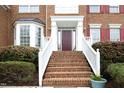 Stairway leading to a red front door with white trim and well manicured bushes at 122 Banyon Tree Ln, Cary, NC 27513
