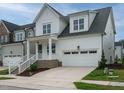 Attractive two-story home featuring white siding, a welcoming front porch, and an attached two-car garage at 1225 Barreto Drive Dr, Wendell, NC 27591