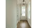 Bright foyer with hardwood floors, modern lighting, and a glass-paneled front door and sidelight at 1225 Barreto Drive Dr, Wendell, NC 27591