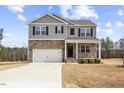 Charming two-story home featuring stone accents, gray siding, and a well-maintained lawn at 140 Baker Farm Dr, Youngsville, NC 27596