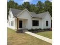 Stylish modern farmhouse with a walkway, manicured lawn, black trim windows, and eye-catching curb appeal at 148 Mohawk Dr, Louisburg, NC 27549