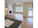 Open-concept living room featuring a fireplace, hardwood floors, neutral paint and natural light from the large windows at 148 Mohawk Dr, Louisburg, NC 27549