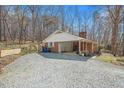 Exterior of home with gravel drive, fenced yard, and covered patio at 1614 Clearwater Lake Rd, Chapel Hill, NC 27517