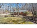 Side view of a brick home with a covered porch and mature trees at 1614 Clearwater Lake Rd, Chapel Hill, NC 27517