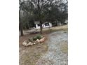 Quaint home surrounded by trees, featuring a gravel driveway and a cozy hammock for relaxation at 186 Frank Cash Rd, Timberlake, NC 27583
