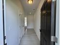 Bright hallway with neutral walls and light wood-look floors leads to other rooms in this new home at 192 Bruce Dr, Dunn, NC 28334