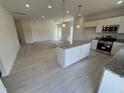 Open-concept kitchen featuring a central island, granite countertops, and stainless steel appliances at 192 Bruce Dr, Dunn, NC 28334