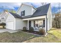 Charming two-story home with a well-manicured lawn, attached garage, and a cozy front porch sitting area at 201 Timber Meadow Lk, Fuquay Varina, NC 27526