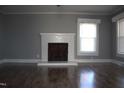 Bright living room featuring a fireplace with white mantle and gorgeous hardwood floors at 2110 Carolina Mill Rd, Burlington, NC 27217