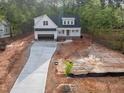 Aerial view of a charming two-story home with a concrete driveway surrounded by trees at 215 Purslane Dr, Franklinton, NC 27525