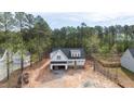A serene aerial view showcases this new home's roofline, two-car garage, landscaping, and wooded surroundings at 215 Purslane Dr, Franklinton, NC 27525