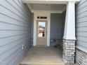 Inviting front porch with stone accents and a classic front door with glass panes at 2454 Englemann Dr # 380, New Hill, NC 27562