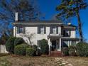 Attractive two-story home with white brick, complemented by lush greenery and a clear blue sky at 2521 St Mary'S St, Raleigh, NC 27609