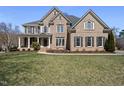Elegant brick home with a manicured lawn and a welcoming front porch at 301 Highwood Pines Pl, Cary, NC 27519
