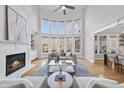 Spacious living room with soaring ceilings, large windows, a cozy fireplace, and stylish, neutral-toned furniture at 301 Highwood Pines Pl, Cary, NC 27519