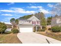 Charming two-story home with a stone and siding facade, red shutters, a well-manicured lawn, and an attached two-car garage at 3100 Cynthiana Ct, Raleigh, NC 27610