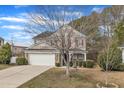 Charming two-story home with a stone and siding facade, red shutters, a well-manicured lawn, and an attached two-car garage at 3100 Cynthiana Ct, Raleigh, NC 27610