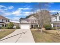 Charming two-story home with a stone and siding facade, red shutters, a well-manicured lawn, and an attached two-car garage at 3100 Cynthiana Ct, Raleigh, NC 27610