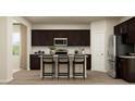 Well-equipped kitchen featuring dark cabinets, stainless steel appliances, granite counters, and a central island at 3725 Massey Pond Trl, Raleigh, NC 27616