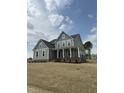 Beautiful gray home with a welcoming front porch, white columns and trim, and meticulously maintained lawn at 405 Rising Star Dr, Clayton, NC 27520