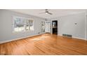Bright living room with hardwood floors, modern ceiling fan, and natural light from the windows at 407 Knight Ave, Cary, NC 27511