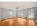 Bright living room with hardwood floors, modern ceiling fan, and natural light from the windows at 407 Knight Ave, Cary, NC 27511