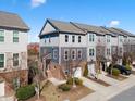 Inviting two-story townhome with a one-car garage, brick accents, landscaping, and gray wood-look siding at 4116 Sykes St, Cary, NC 27519