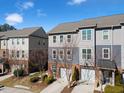 Stylish two-story townhome featuring a one-car garage, brick accents, and gray wood-look siding at 4116 Sykes St, Cary, NC 27519