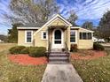 Inviting cottage-style home with a sidewalk and covered entry and a yellow exterior at 415 Caswell St, Smithfield, NC 27577