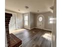 Open living room featuring fresh paint, hardwood flooring, a brick fireplace, and a decorative door at 415 Caswell St, Smithfield, NC 27577