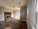 Spacious living room showcasing beautiful floors, fresh paint, and a charming brick fireplace at 415 Caswell St, Smithfield, NC 27577