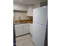 Well-lit kitchen featuring white cabinets, wooden countertops, stainless steel sink and a modern refrigerator at 500 Umstead Dr # 105D, Chapel Hill, NC 27516
