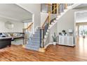 Bright foyer featuring hardwood floors, staircase with iron railing, and open access to the living room at 505 Redford Place Dr, Rolesville, NC 27571