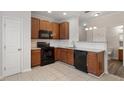Well-lit kitchen with wooden cabinets, tile backsplash, and black appliances at 650 Ganyard Farm Way # 4, Durham, NC 27703