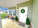 Inviting front porch with rocking chairs, plants and a welcoming wreath on the front door at 897 W Main St, Benson, NC 27504