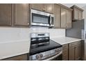 Close-up showcasing stainless steel appliances, white subway tile backsplash and granite countertops in a modern kitchen at 92 Ripple Way # 315, Clayton, NC 27520