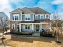 Charming two-story home with stone accents, gray siding, and a cozy front porch at 120 Restonwood Dr, Apex, NC 27539