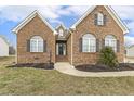 Beautiful brick home with well-maintained landscaping, arched windows, and a welcoming front entrance at 124 D'Ango Cir, Angier, NC 27501