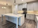 Modern kitchen features a spacious island, stainless steel appliances, and elegant pendant lighting at 1794 Parham Dr, Graham, NC 27253