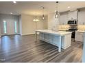 Open-concept kitchen boasts a large center island, stainless steel appliances, and modern gray cabinets at 1794 Parham Dr, Graham, NC 27253