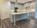 Bright kitchen with a large island, gray cabinets, stainless appliances, and stylish pendant lights at 1794 Parham Dr, Graham, NC 27253
