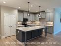 Bright eat-in kitchen featuring stainless appliances, granite countertops, and gray cabinets at 1794 Parham Dr, Graham, NC 27253