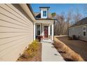 Inviting front porch with red door, potted flowers and walkway lighting at 2109 Flycatcher Ln, Fuquay Varina, NC 27526