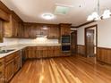Well-lit kitchen with wood cabinets, stainless steel oven, and hardwood floors at 241 Beachers Brook Ln, Cary, NC 27511