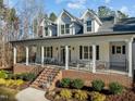 Inviting front porch with brick base, black railings, and ample seating space, perfect for relaxing outdoors at 290 Whistlers Cv, Louisburg, NC 27549