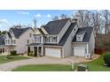 Charming two-story home with a well-manicured lawn, gray siding, and a two-car garage at 307 Sugarberry Ln, Clayton, NC 27527
