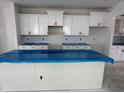 A kitchen showcases white cabinets and a spacious center island, ready for customization and modern appliances at 316 White Oak Garden Way # 217, Garner, NC 27529