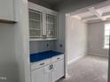 An elegant kitchen area featuring white cabinets with glass fronts and black hardware, awaiting finishing touches at 316 White Oak Garden Way # 217, Garner, NC 27529